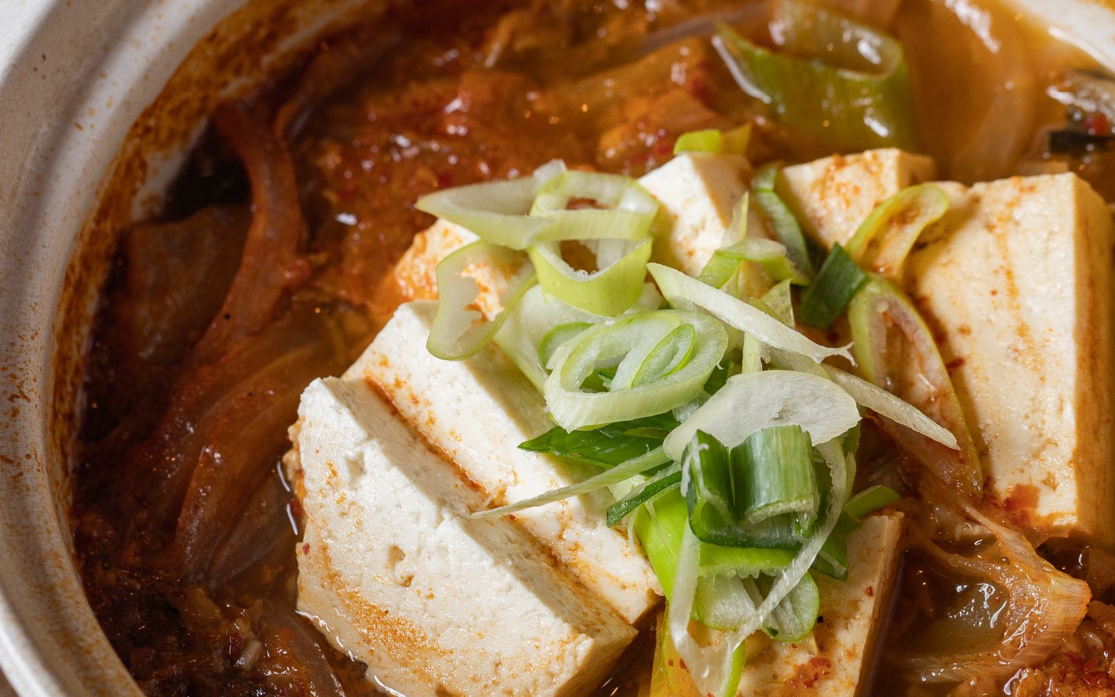 뚝배기에 담겨 끓는 김치찌개와 두부, 쪽파