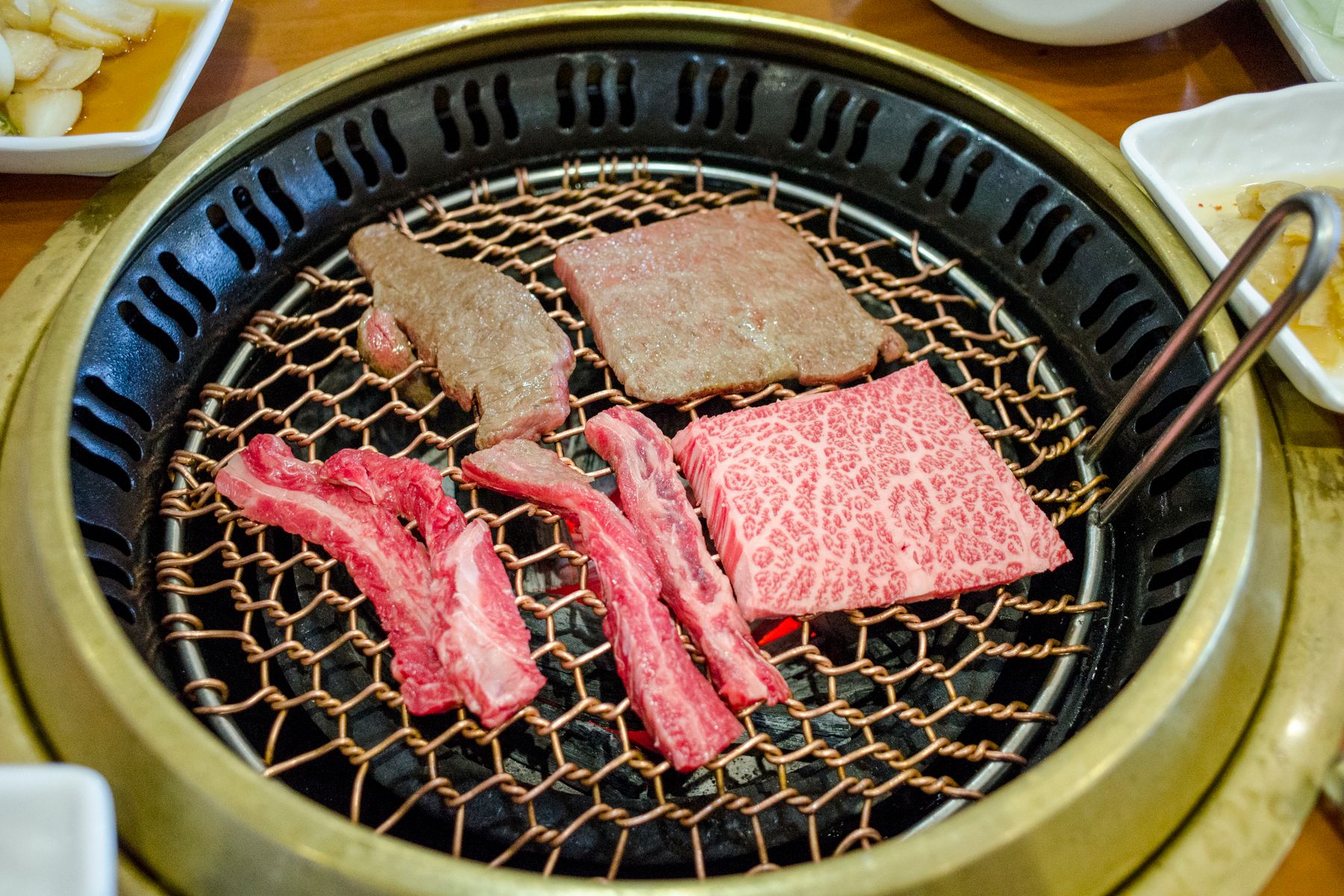 참숯 화로 위에서 익어가는 한우 구이 조각 접사